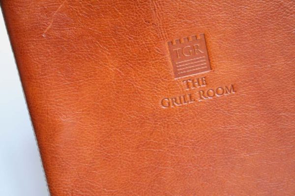 Beautiful full leather menu covers in light Tan Real Hide. De-Bossed logo stamped into the front panel of the menus. Internal screw fixing spine on the inside of the menus to take multiple pages.